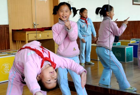 Three girls of quintuplets children of Jiao Baocun and his wife Wang Cuiying play in the dance class at Experimental Primary School of Fengtai District in Beijing on October 29, 2009. 