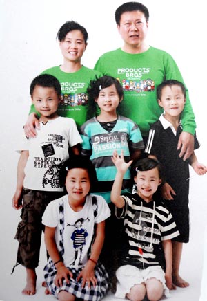 Photo taken on October 30, 2009 shows a family photo of quintuplets children, the father Jiao Baocun and his wife Wang Cuiying.