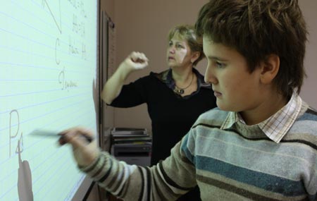 Photo taken on October 26, 2009 shows Dobrynin Denis writes answers on the tabula during a mathematic lesson in Moscow, capital of Russia. 