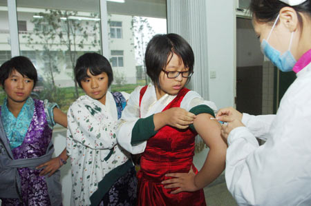 Students from the 35th Middle School of Hefei receive free vaccination against the A/H1N1 influenza in Hefei, capital of east China's Anhui Province, November 10, 2009. About 15,000 citizens in Hefei mainly working in public service sectors have received the vaccination since November 6.