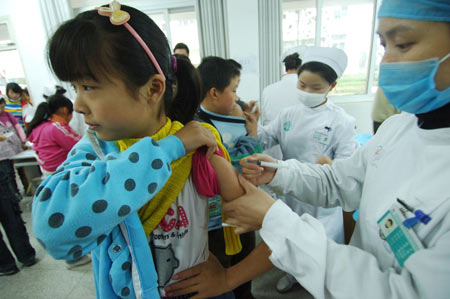 A student from the 35th Middle School of Hefei receives free vaccination against the A/H1N1 influenza in Hefei, capital of east China's Anhui Province, November 10, 2009. About 15,000 citizens in Hefei mainly working in public service sectors have received the vaccination since November 6.