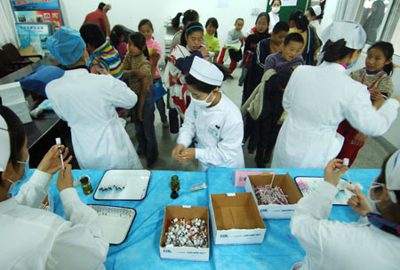 Students from the 35th Middle School of Hefei receive free vaccination against the A/H1N1 influenza in Hefei, capital of east China's Anhui Province, November 10, 2009. About 15,000 citizens in Hefei mainly working in public service sectors have received the vaccination since November 6. 