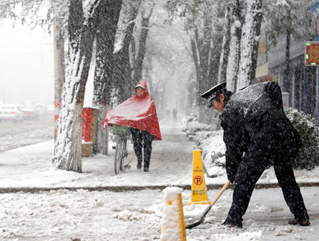 A man clears snow in Taiyuan, capital of north China&apos;s Shanxi Province, November 10, 2009. Most parts in north and northwest China witnessed a snowfall on Tuesday.