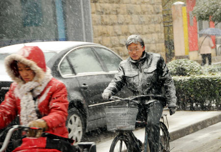 Residents ride bike in snow on a street in Shijiazhuang, capital of north China&apos;s Hebei Province, November 10, 2009. Most parts in north and northwest China witnessed a snowfall on Tuesday.