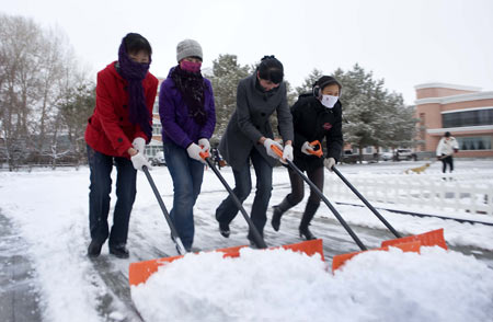 People clean up snow on a road in Fuyun County, northwest China&apos;s Xinjiang Uygur Autonomous Region, November 10, 2009. Most parts in north and northwest China witnessed a snowfall on Tuesday.