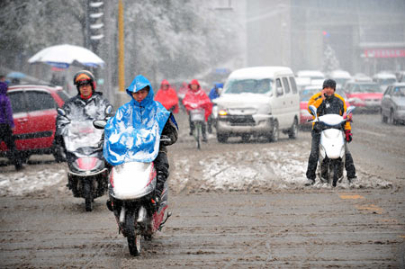 Residents ride in snow on a street in Taiyuan, capital of north China&apos;s Shanxi Province, November 10, 2009. Most parts in north and northwest China witnessed a snowfall on Tuesday. 