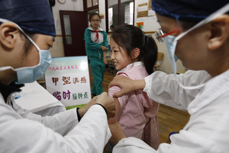 A pupil receives A/H1N1 flu vaccination in Shanghai municipality of China, November 10, 2009. The A/H1N1 flu vaccination program among students of elementary schools and middle schools of Shanghai was kicked off on Tuesday.