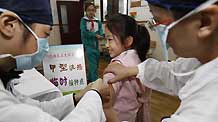 A pupil receives A/H1N1 flu vaccination in Shanghai municipality of China, November 10, 2009. The A/H1N1 flu vaccination program among students of elementary schools and middle schools of Shanghai was kicked off on Tuesday.
