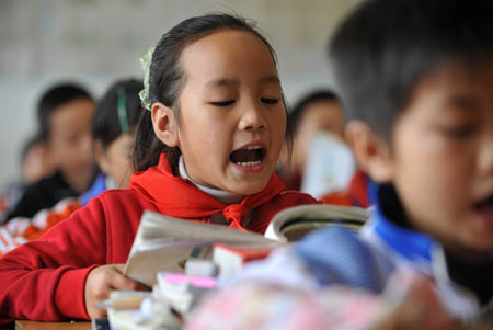 Gao Yaqian, an 8-year-old pupil, reads aloud text in Chinese-language class at the Central Primary School of Lirang Town in Liangping County, southwest China's Chongqing municipality, October 30, 2009. 