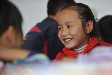 Gao Yaqian, an 8-year-old pupil of the Central Primary School of Lirang Town, discusses with classmates in a Chinese-language class, in Liangping County, southwest China's Chongqing municipality, October 30, 2009.