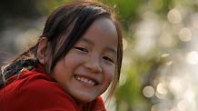 Gao Yaqian, an 8-year-old pupil of the Central Primary School of Lirang Town, smiles while enjoying a leisure moment at home, in Liangping County, southwest China's Chongqing municipality, November 4, 2009.