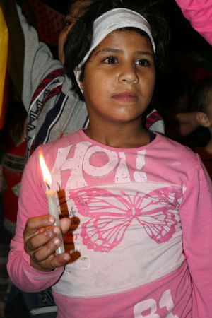 A Palestinian girl holds a candle during a candle-lighting ceremony marking the fifth anniversary of late Palestinian leader Yasser Arafat's death in the West Bank town Qalqilya, November 10, 2009. 