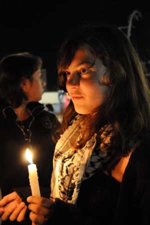 A Palestinian girl holds a candle at the grave of the late Palestinian leader Yasser Arafat during a vigil marking the fifth anniversary of Arafat's death in the West Bank city of Ramallah, November 10, 2009.