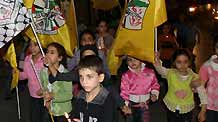 Palestinian kids hold flags and candles during a candle-lighting ceremony marking the fifth anniversary of late Palestinian leader Yasser Arafat's death in the West Bank town Qalqilya, November 10, 2009. Yasser Arafat passed away in Paris on November 11, 2004.