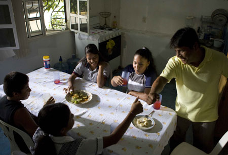 Mexican girl Iris Alvarez (R3 in the back) has lunch with her family in Acapulco, Mexico, October 31, 2009.