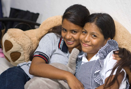 Mexican girl Iris Alvarez(L) poses for photos with her younger sister at home in Acapulco, Mexico, October 30, 2009. 