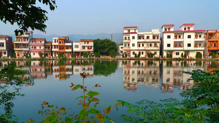 The photo taken on October 25, 2009 by Zhu Mengdan shows a picturesque rural scenery where green trees and placid pond surround residential buildings. I hope that the local residents will cherish the beautiful environment.