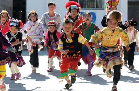 Dainzin Gyayang (R, front) plays with his companions in the Lijiang Ethnic Orphanage in Lijiang City, southwest China's Yunnan Province, October 25, 2009.