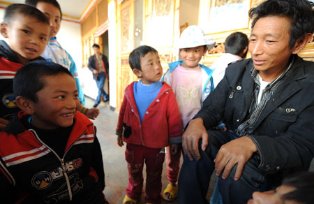 Dainzin Gyayang (L, front) and his teacher Sonam talk with each other in the Lijiang Ethnic Orphanage in Lijiang City, southwest China's Yunnan Province, October 24, 2009.