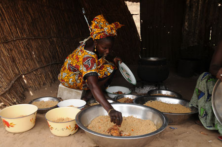 Lamine's mother cooks traditional meal for Xinhua journalists at home in a village 80 kilometers north of Dakar, capital of Senegal, October 27, 2009.