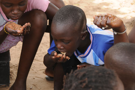 Lamine has dinner at home in a village 80 kilometers north of Dakar, capital of Senegal, October 27, 2009.