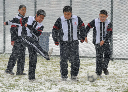 Students play soccer in snow in Beijing, capital of China, November 12, 2009. Snowfall continued in most parts of north and central China on Thursday.