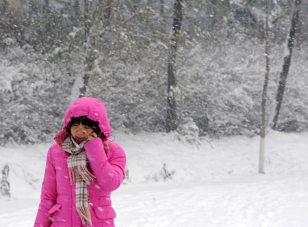 A woman walks in snow on a snow-covered road in Shenyang, capital of northeast China's Liaoning Province, on November 13, 2009. The heaviest snowfall this winter hit Liaoning Province since the afternoon of November 12. 