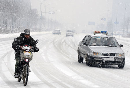 Vehicles run in snow on a snow-covered road in Shenyang, capital of northeast China's Liaoning Province, on November 13, 2009. The heaviest snowfall this winter hit Liaoning Province since the afternoon of November 12.