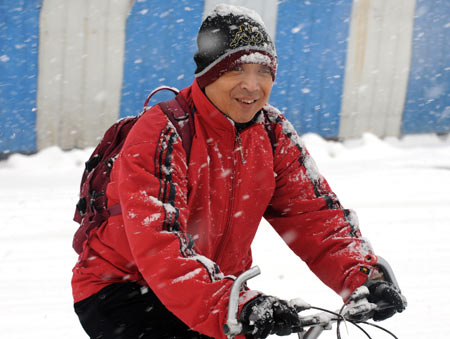 A man rides bicycle in snow on a snow-covered road in Shenyang, capital of northeast China's Liaoning Province, on November 13, 2009. The heaviest snowfall this winter hit Liaoning Province since the afternoon of November 12. 