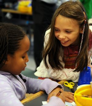 Photo taken on Oct. 27, 2009 shows Sarah (R) discusses with her classmate in the classroom.(Xinhua/Shen Hong)