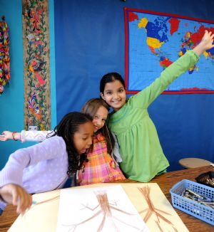 Photo taken on Oct. 27, 2009 shows Sarah (C) and her classmates celebrate finishing the drawing of trees of All Saints' Day in the classroom.(Xinhua/Shen Hong)