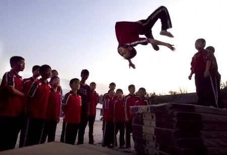 He Minxian, a 9-year-old kid, practises somersault in the Shaolin Tagou Kung Fu (Martial Art) Institute at the foot of Mountain Song in Dengfeng, a city of central China's Henan Province, October 12, 2009. 