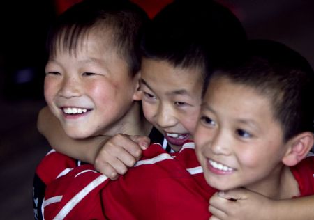 He Minxian (L), a 9-year-old kid, and his classmates watch reporting performance of students of high grades in the Shaolin Tagou Kung Fu (Martial Art) Institute at the foot of Mountain Song in Dengfeng, a city of central China's Henan Province, October 12, 2009.