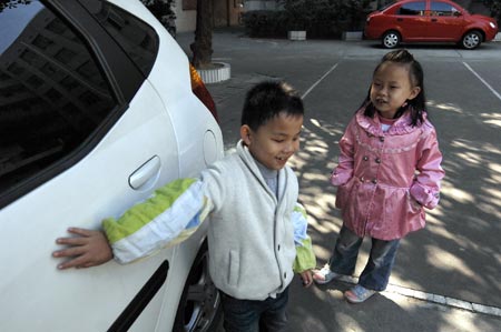 Chen Yu (L), a 7-year-old blind boy, checks an automobile near the Nanchang Blind Children's School in Nanchang, capital city of east China's Jiangxi Province, on November 4, 2009.