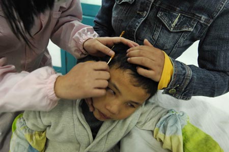 Chen Yu, a 7-year-old blind boy, gets treatment in the Nanchang Blind Children's School in Nanchang, capital city of east China's Jiangxi Province, on November 4, 2009.