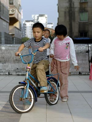 Chen Yu (L), a 7-year-old blind boy, learns riding on his elder sister's bike in Nanchang, capital city of east China's Jiangxi Province, on November 4, 2009. 