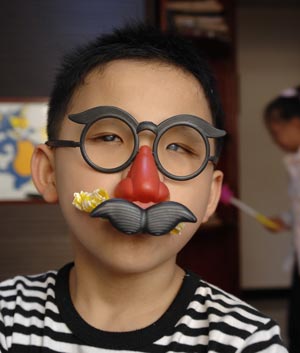 Chen Yu, a 7-year-old blind boy, wears a joker mask in the Nanchang Blind Children's School in Nanchang, capital city of east China's Jiangxi Province, on October 31, 2009.