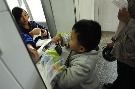 Chen Yu, a 7-year-old blind boy, buys the meal in the dining time at the Nanchang Blind Children's School in Nanchang, capital city of east China's Jiangxi Province, on November 4, 2009.