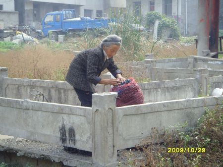 Photo taken by 11-year-old pupil Zhang Ling of grade 6 with the Wang Fang Elementary School shows an old woman picking garbage at a village in Hefei, capital of east China's Anhui Province.