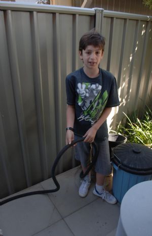 Photo taken on November 3, 2009 shows Jordan Hartman holding a water pipe connected back to bathroom at backyard of home in Melbourne of Australia.