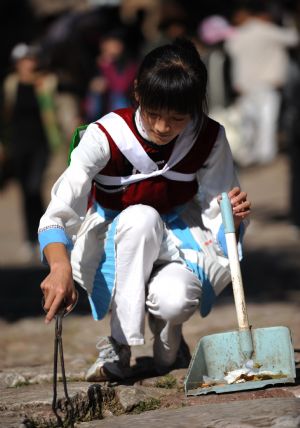 He Siqi collects trash in the ancient town of Shuhe in Lijiang City, southwest China&apos;s Yunnan Province, October 28, 2009.