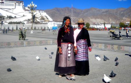 The photo I took on October 31, 2009 shows two women posing for pictures at the Potala Palace Square in Lhasa.