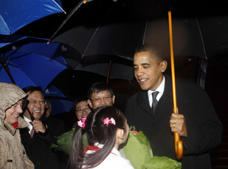 A girl presents a bouquet to US President Barack Obama after he arrives at Shanghai Pudong International Airport on November 15, 2009.