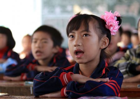 Wang Jinlian attends class at Minzu Elementary School in Rongshui Miao Autonomous County, southwest China's Guangxi Zhuang Autonomous Region, November 6, 2009.