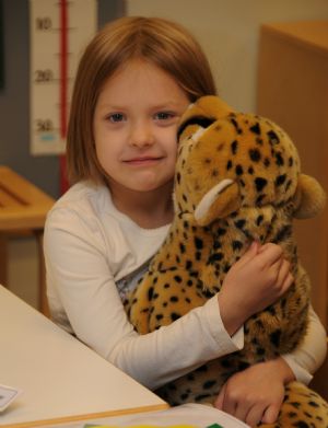 A girl holding a toy poses for a photo at a kindergarten in Finland, on October 23, 2009.