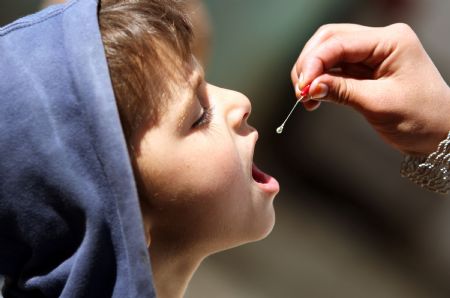 An Afghan health worker administers polio vaccine to a child in the old city of Kabul, capital of Afghanistan, November 16, 2009. Afghanistan launched a three-day nationwide polio vaccination in order to immunize children less than five-year-old against polio. Afghanistan aims to eradicate polio in the country till 2011. 