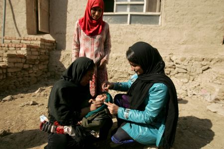 An Afghan health worker administers polio vaccine to a child in the old city of Kabul, capital of Afghanistan, November 16, 2009.