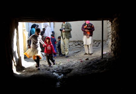 Two Afghan kids run to receive polio vaccine in the old city of Kabul, capital of Afghanistan, November 16, 2009.