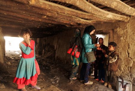 An Afghan health worker administers polio vaccine to a child in the old city of Kabul, capital of Afghanistan, November 16, 2009.