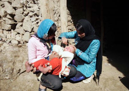 An Afghan health worker administers polio vaccine to a child in the old city of Kabul, capital of Afghanistan, November 16, 2009. 